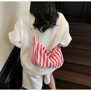 Sac demi-lune en toile rayée rose avec bandoulière réglable porté par mannequin