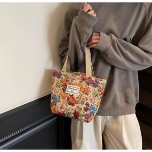 Détail du sac cabas jacquard vintage avec tissu floral texturé et poignées en beige doux
