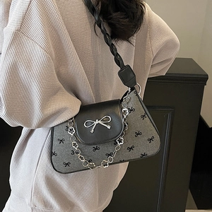 Gray bow-print underarm bag with silver metallic bow buckle and leather chain strap