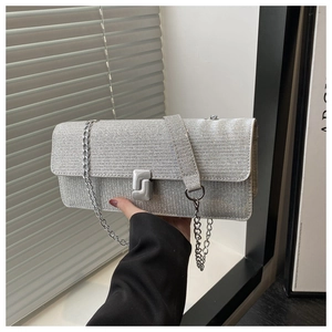 Detail of silver sequined handbag with metal clasp and chain strap for evening events