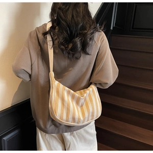 Détail du sac demi-lune en toile à rayures jaunes et blanches avec tissage à chevrons