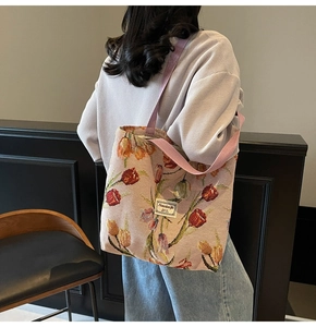 Detail of floral jacquard tote bag with tulip pattern on model in a soft lit room