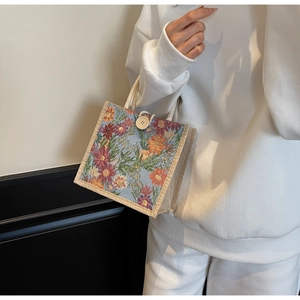Close-up of vintage floral jacquard tote bag with woven handles and a decorative wooden button