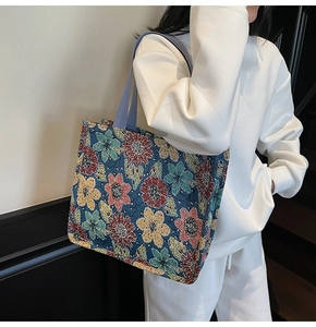 Detailed view of floral jacquard tote bag with vibrant embroidery and purple handles