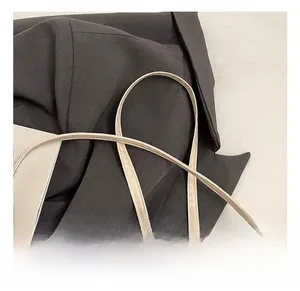 Detail of adjustable off-white leather strap with silver buckle for crossbody bag