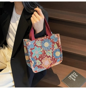 Close-up of vintage floral jacquard pattern on a large burgundy tote bag with canvas handles