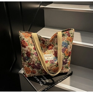 Détail du sac cabas en jacquard floral vintage avec sangles en toile et étiquette de marque