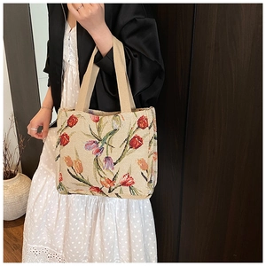 Dettaglio della borsa tote floreale con ricamo di tulipani rossi e manici in tessuto