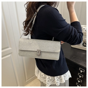 Silver glitter shoulder bag featuring a unique geometric metal clasp and chain strap