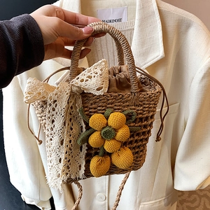 Handmade woven straw handbag with yellow knit flowers and white lace bow for beach vacation