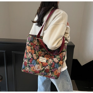 Détail du sac cabas en toile jacquard fleurie avec sangles bordeaux et étiquette tissée