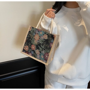 Detail of floral tapestry jacquard pattern on a linen tote bag with woven rope handles