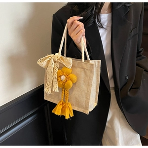 Dettaglio borsa in lino con ciondolo a girasole carino e nastro di pizzo decorativo