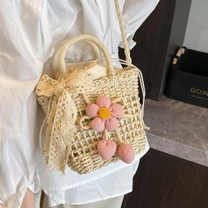 Handmade woven straw bag with pink flower charm and lace bow for beach vacation