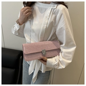 On-body view of a pink glitter square shoulder bag with silver chain strap and metal clasp