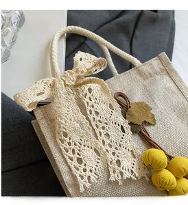 Detailed texture of linen lunch bag with lace bow and yellow fruit charm pendant