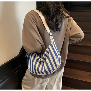 Détail du sac hobo en toile à rayures bleues et blanches avec bandoulière réglable