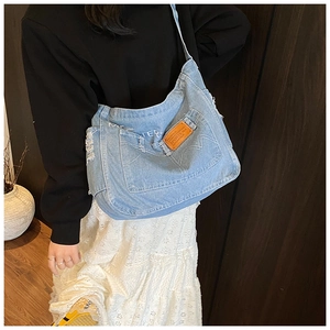 Detail of light blue denim tote bag with Master print and frayed edge craftsmanship