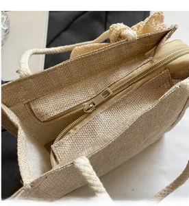 Close-up of smooth metal zipper and woven texture on beige summer handbag