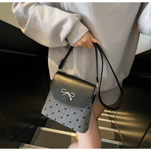 Detail of grey wool bucket bag with black polka dots and silver metal bow buckle