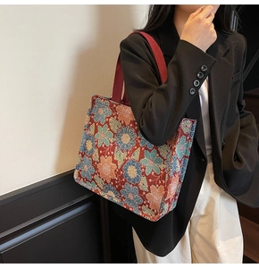 Close-up of floral jacquard tote bag with vintage embroidery texture and red strap