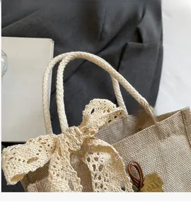 Close-up of woven jute handbag featuring lace bow and sturdy braided rope handles