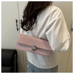 Close-up of pink glitter crossbody bag with silver chain strap and S-shaped lock buckle