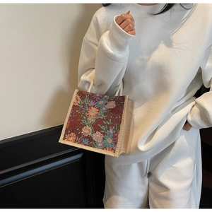Detailed close-up of a floral jacquard linen lunch bag with white rope handles for women