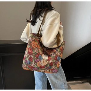 Détail du sac cabas en jacquard floral vintage avec larges bandoulières marron et étiquette