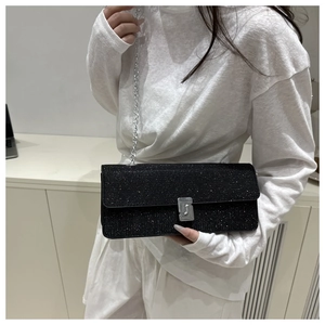 Detail of black glitter crossbody bag with silver chain strap and metal buckle