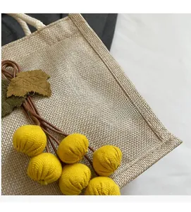 Detail of linen handbag with yellow fruit decor and white cotton rope handle