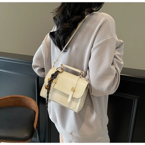 Detail of off-white PU leather square bag with gold hardware and woven tassel detail