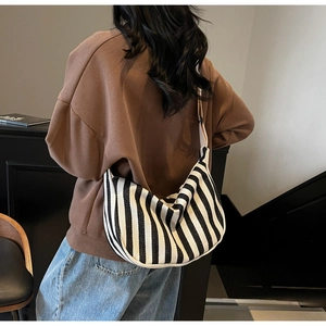 Sac hobo en toile à rayures noires et blanches porté à l'épaule pour un style décontracté