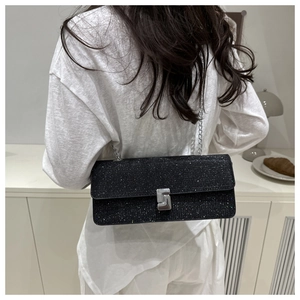 Detail of black glitter shoulder bag with silver chain strap and geometric metal buckle