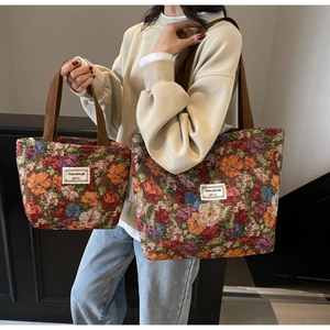 Détail d'un sac cabas en toile à fleurs vintage avec texture et bandoulière marron