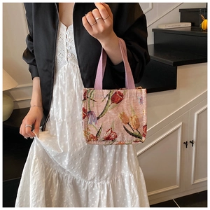 Vista dettagliata della borsa tote jacquard con tulipani e manici viola