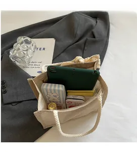 Spacious interior of beige canvas tote bag holding a tablet and daily accessories