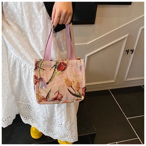 Dettaglio della borsa tote in jacquard con tulipani colorati e manici lilla