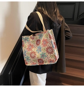 Ethnic floral jacquard tote bag with wide shoulder strap shown in a lifestyle scene