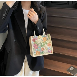 Artistic linen tote bag with colorful floral print and vintage button closure detail