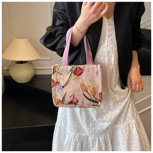 Dettaglio della borsa tote jacquard tulipano con trama floreale rosa e manici viola