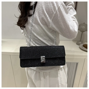 Detailed view of black glitter shoulder bag with silver chain strap on model back