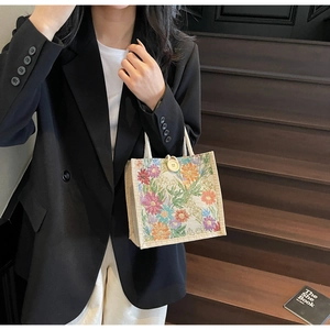 Detailed close-up of a floral linen tote bag with colorful jacquard and woven rope handle