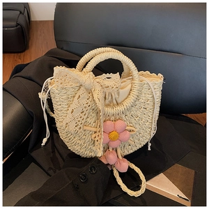 Détail du sac en paille tissé à la main avec nœud en dentelle, fleur au crochet et doublure