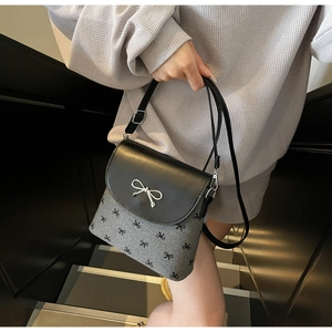 Close-up of bow knot metal clasp and printed pattern on grey shoulder bucket bag