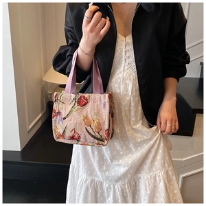 Dettaglio borsa tote vintage in jacquard con motivi di tulipani e manici viola