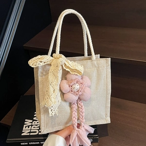 Elegante borsa in lino beige con fiocco in pizzo e ciondolo a fiore su scale