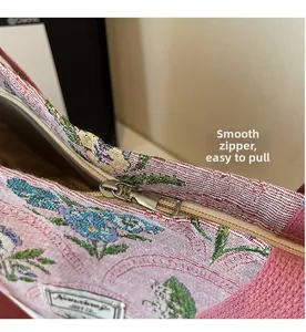 Close-up of smooth metal zipper and floral woven jacquard fabric on the tote bag