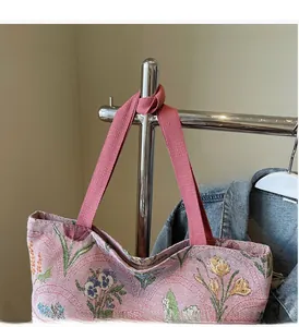Detail of pink floral jacquard tote bag with wide webbing handles and tulip pattern