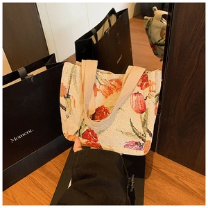Dettaglio della borsa tote in tessuto beige con motivi floreali di tulipani
